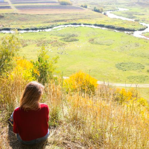 Mädchen blickt ins grüne Flusstal